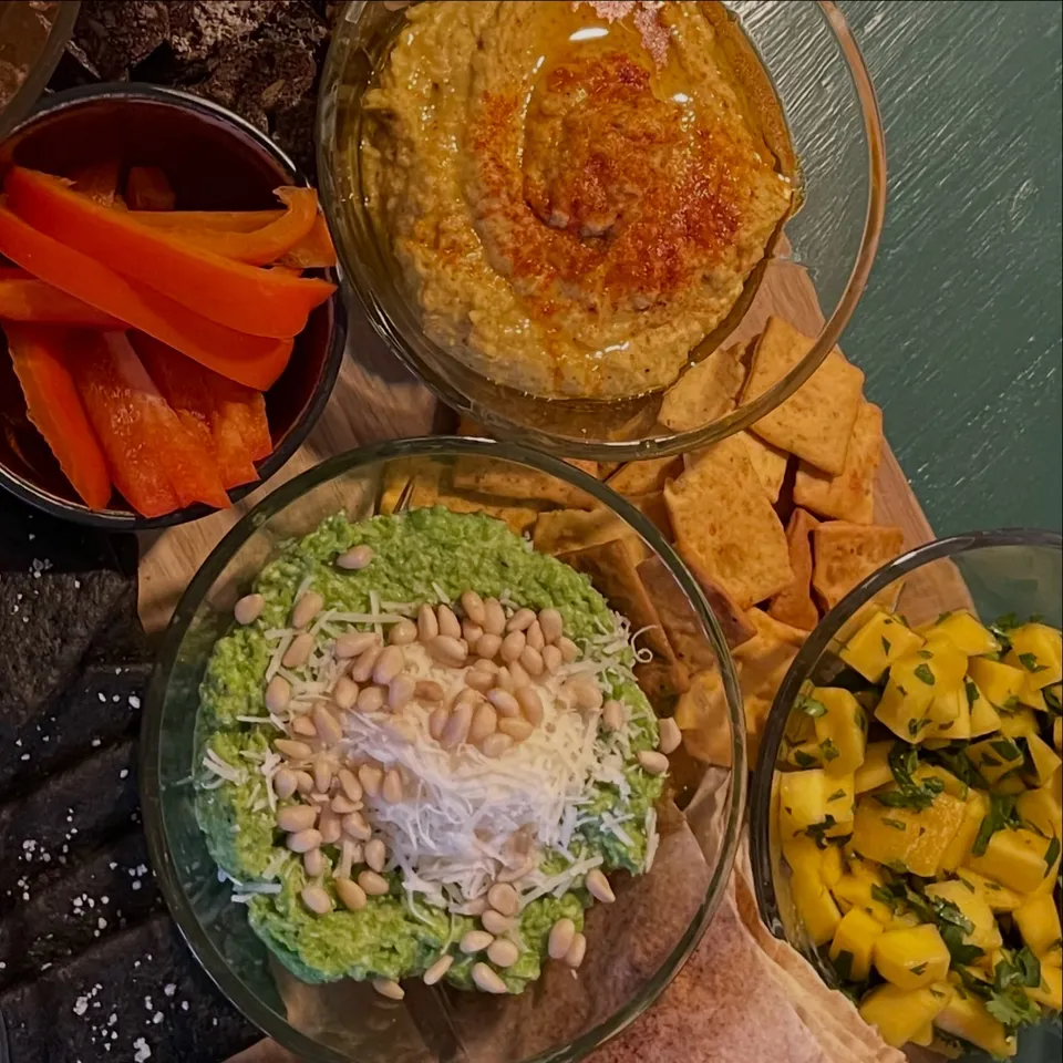 Skåle med hummus, ærtepuré med pinjekerner, mangosalsa og pitachips