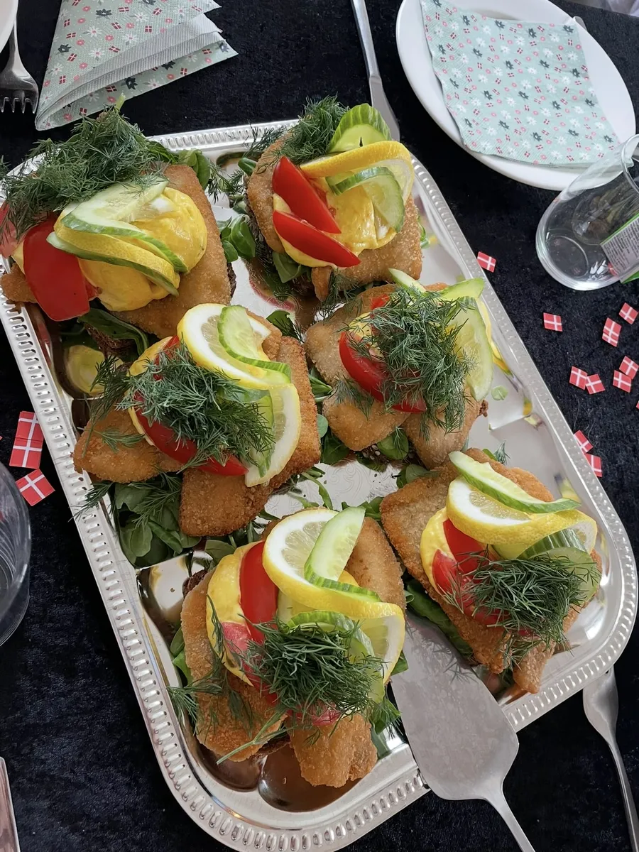 Smørrebrød med stegt fiskefilet, citron og dild på et sølvfad