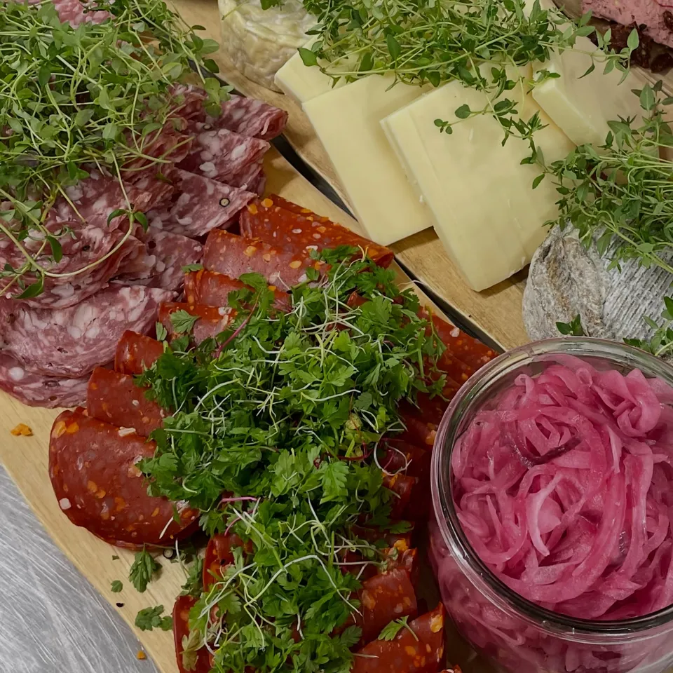 Spegepølse, chorizo og ost med krydderurter og syltede rødløg